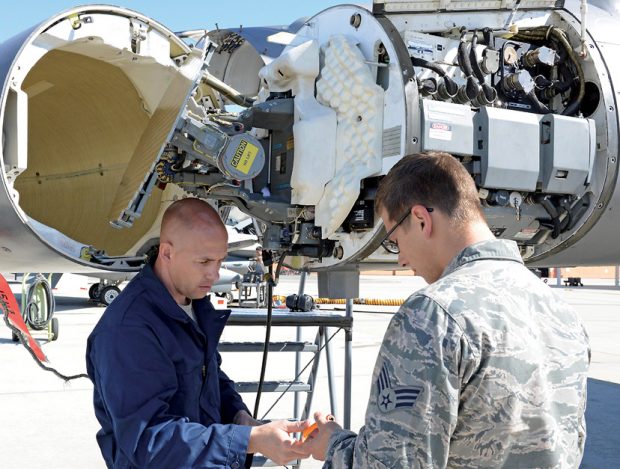 Two members of the U.S. Air Force do pressurization maintenance on an F-16 Fighting Falcon radar waveguide. Such maintenance is now done based on pre-established rules such as hours of use, but thanks to digitalization, newer aircraft are being delivered with the capability to self-report maintenance needs using sophisticated IoT-based sensors. Image courtesy of the U.S. Air Force; Kenji Thuloweit, photographer.